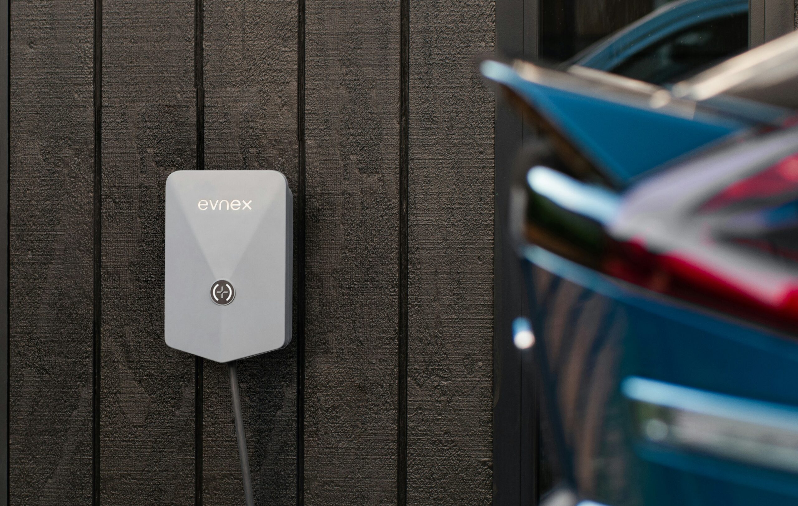 Charging an EV with rooftop solar: an electric car plugged into a home wall charger
